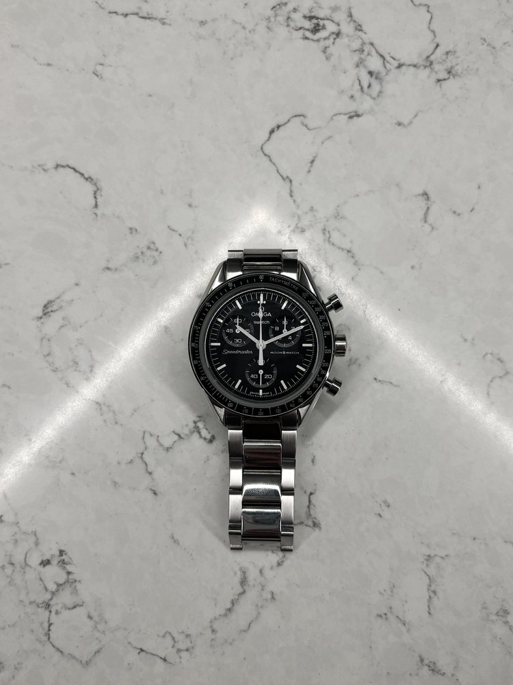 Modded MoonSwatch with a black dial on a marble surface